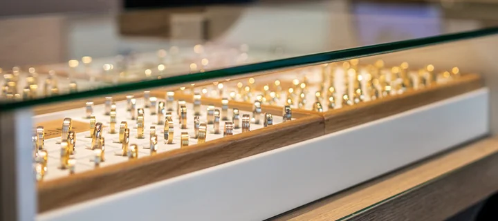 Wystawa jubilerska: rzędy złotych i srebrnych pierścionków w kasetkach pod szkłem